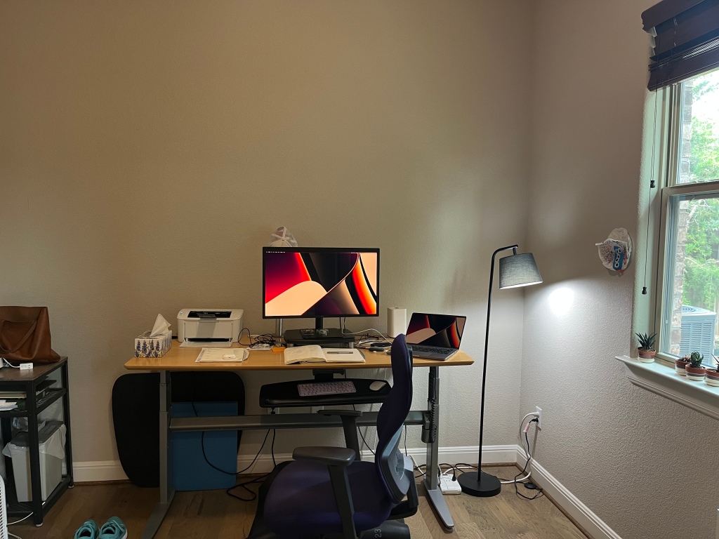 A home office of one's own. Desk, chair, keyboard, monitor, laptop, printer, and more. All very cosy.